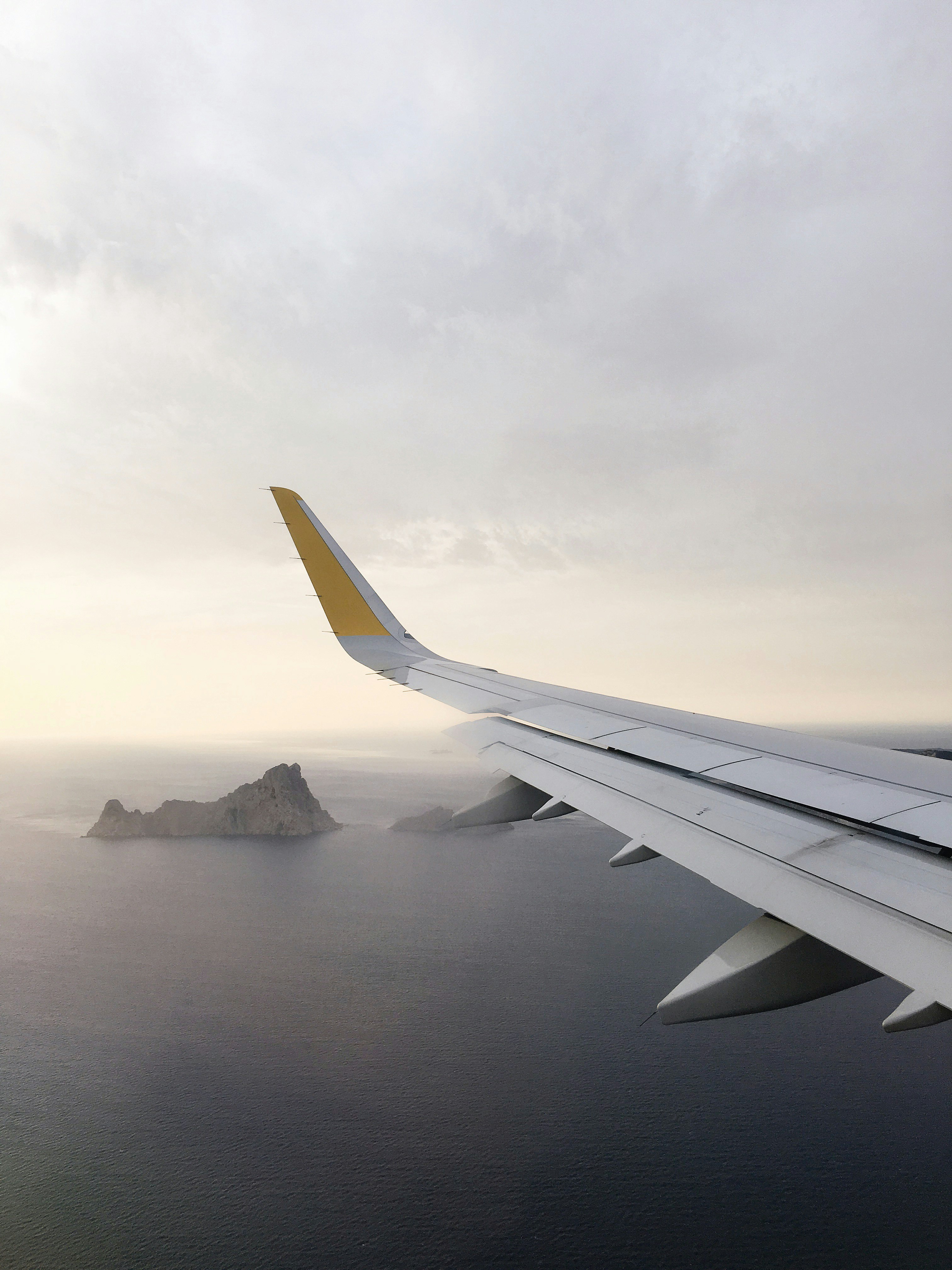 airplane wing above body of water during daytime